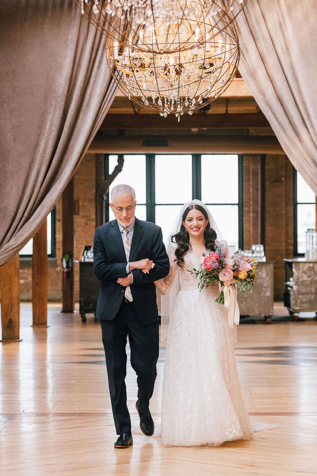 Bride walking in with her father at wedding reception Skyline loft in Bridgeport Arts Center